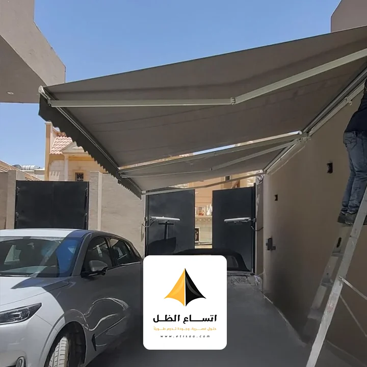 فريق عمل اتساع الظل يقوم بتركيب مظلة سيارات في موقع سكني